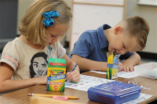 Two students coloring in class. 