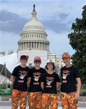 Four robotics team students stand in front of our nation's capitol